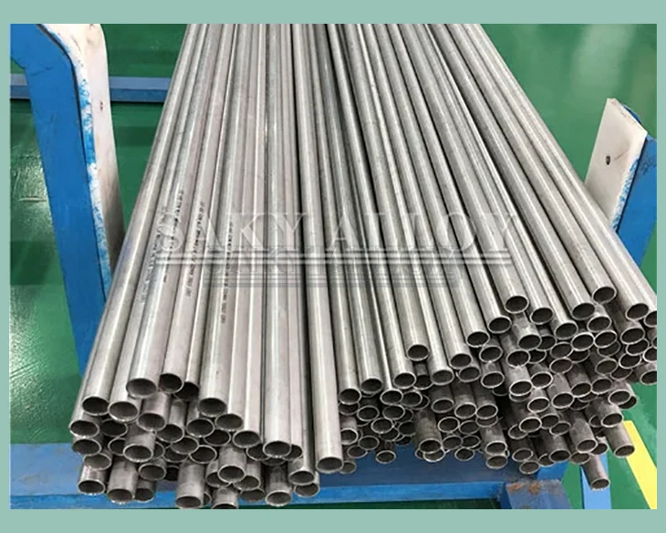 Small-diameter titanium tubes stacked on a blue rack