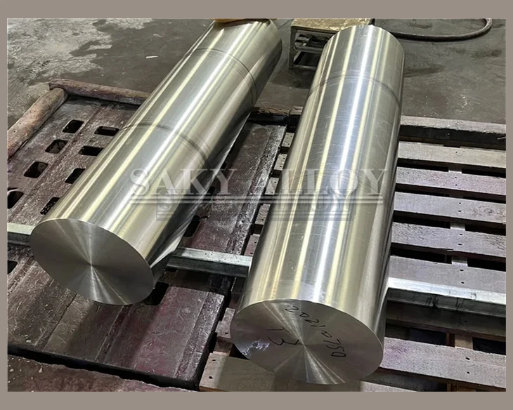 Two large-diameter titanium round bars on a machine bed